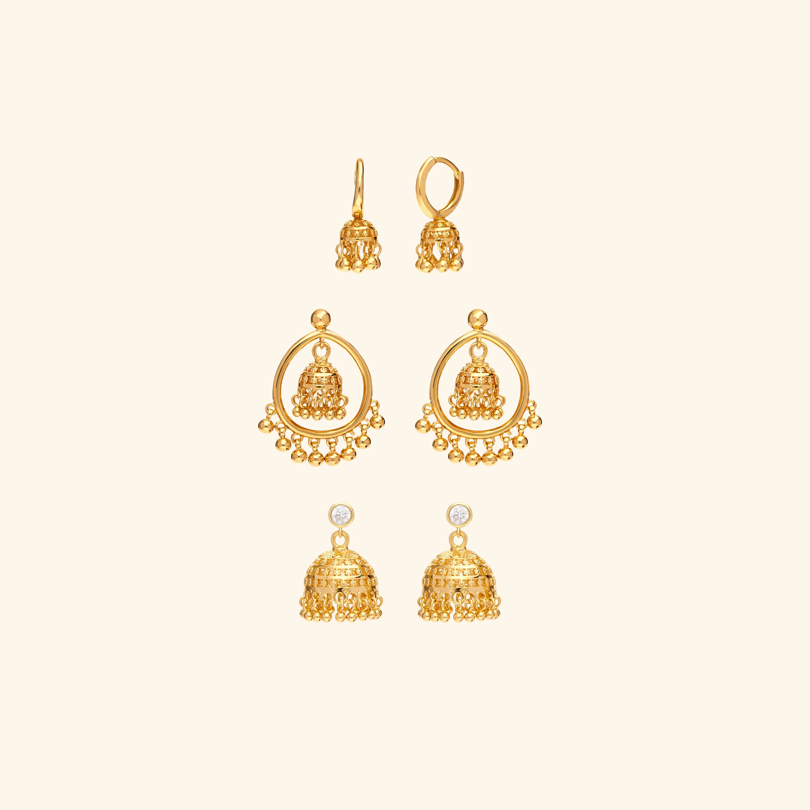 Set of gold earrings on a beige background