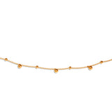 A gold-colored beaded necklace with a delicate chain and small bead drops, isolated on a white background.