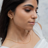 model wearing minimalist gold chain with dark hair