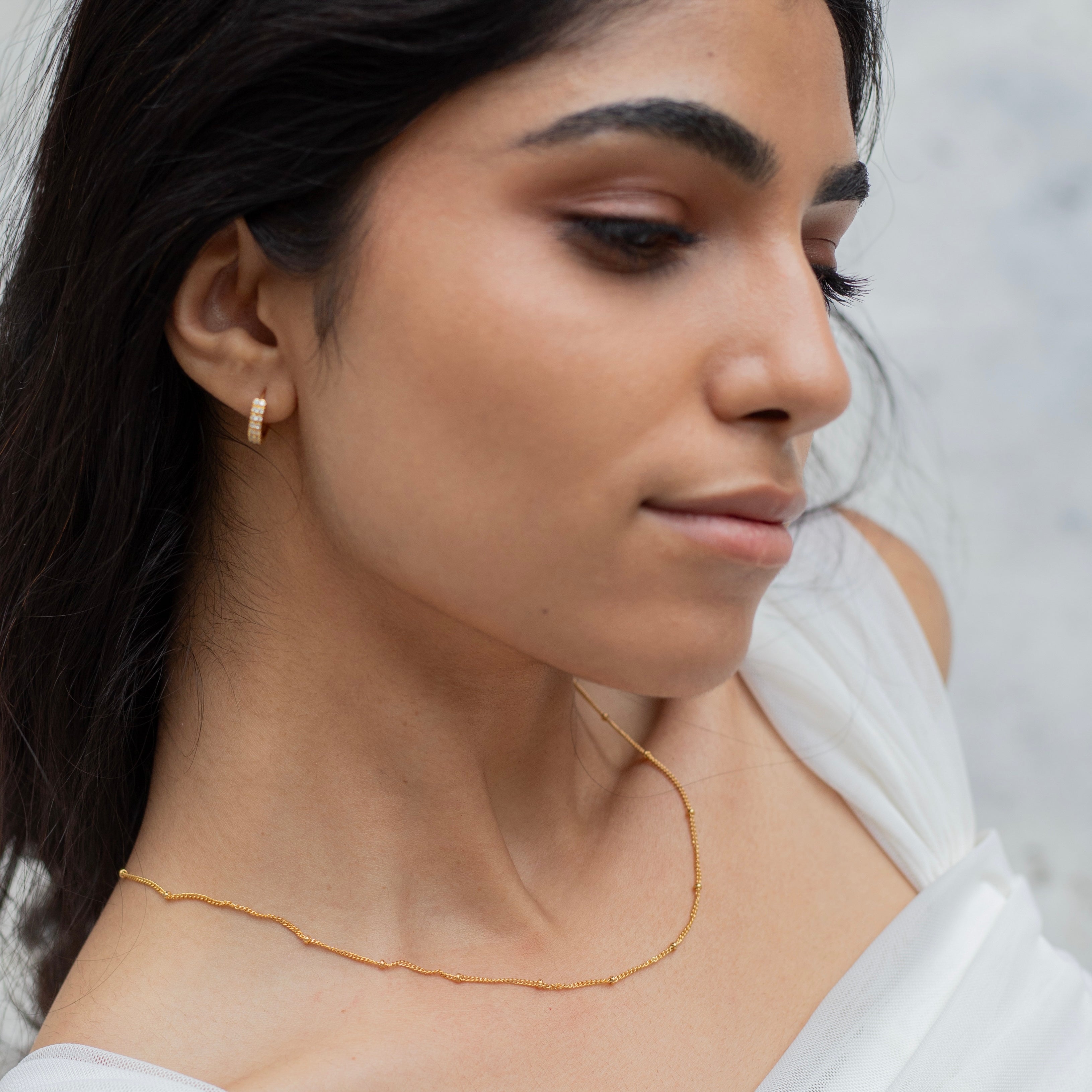 model wearing minimalist gold chain with dark hair